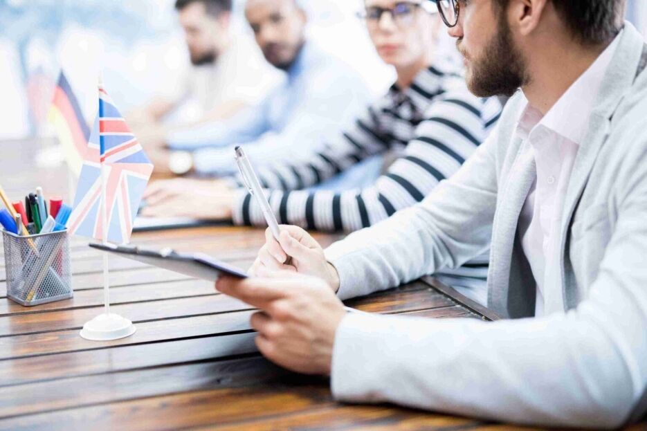 People discussing visa requirements and moving to the UK in an office meeting